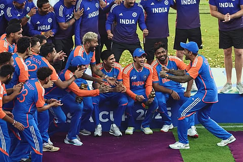 India's captain Suryakumar Yadav (R) playfully pretends to hold the trophy as his team celebrates their Asia Cup 2025 victory against Pakistan