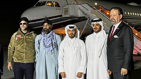 In this photo released by Qatar's Foreign Ministry, U.S. citizen Amir Amiri, second from left, poses before boarding a plane in Kabul, Afghanistan, on Sunday, Sept. 28, 2025, after being released from an Afghan prison.
