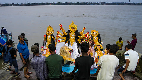 People immerse an idol of Goddess Durga in the Hooghly river at the end of 'Durga Puja' festival, at Baghbazar in Kolkata, West Bengal, Friday, Oct. 3, 2025.