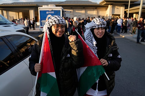 Malaysian sisters Heliza and Hazwani Helmi hold Palestinian flags after arriving in Istanbul, Turkey, with 137 activists from the Global Sumud Flotilla, Saturday, Oct. 4, 2025.