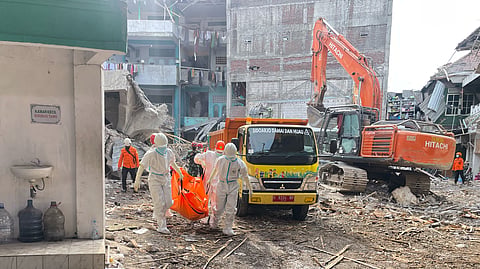 Rescuers carry the body of a newly recovered victim of a building that collapsed at an Islamic boarding school in Sidoarjo, East Java, Indonesia, Sunday, Oct. 5, 2025.