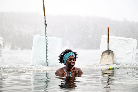 Canda-Leigh Habonimana dips in the waters of Gatineau Park's Meech Lake in Chelsea, Que., during a polar bear dip on New Year's Day, Jan. 1, 2025.
