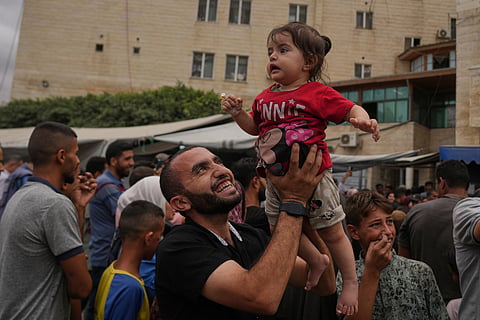 Palestinians celebrate following the announcement that Israel and Hamas have agreed to the first phase of a peace plan to pause the fighting, outside Al-Aqsa Hospital in Deir al-Balah, central Gaza Strip, Thursday, Oct. 9, 2025.