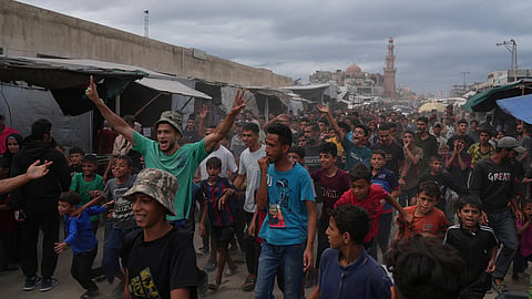 Palestinians celebrate following the announcement that Israel and Hamas have agreed to the first phase of a peace plan to pause the fighting in Khan Younis, southern Gaza Strip, Thursday, Oct. 9, 2025.