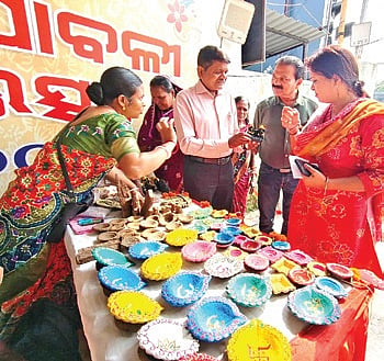 A producer group member showcasing the handmade products to the officials