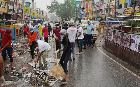Amid heavy rain, DYFI members, along with sanitation workers cleaning waste at Vilakuthoon in Madurai on Tuesday