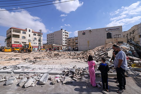 Palestinians inspect the damage following an Israeli raid on the occupied West Bank city of Tubas on October 19, 2025.