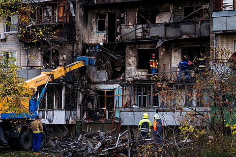 Firefighters work at a destroyed apartment building after a Russian drone attack in Kyiv, Ukraine, Sunday, Oct. 26, 2025.