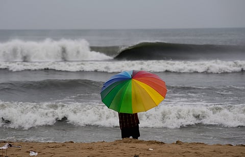 A person looks on as sea waves crash against the shore ahead of the landfall of Cyclone 'Montha', at Marina beach in Chennai, Tuesday, Oct. 28, 2025.