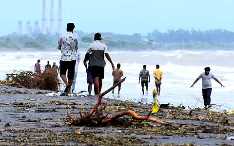 Debris strewn on the shore as people venture into the sea in the aftermath of Cyclone 'Montha', in Kakinada, Andhra Pradesh, Wednesday, Oct. 29, 2025.