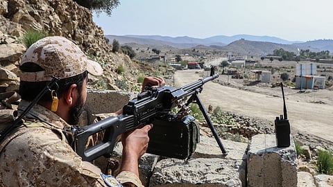 A Taliban security personnel stands guard along a road near the Ghulam Khan zero-point border crossing between Afghanistan and Pakistan in Gurbuz district in the southeast of Khost province on October 20, 2025.
