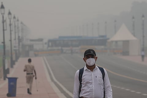 A commuter wears a mask as a layer of smog engulfs the city after deterioration in air quality in Delhi-NCR, at Kartavya Path in New Delhi, Thursday, Oct. 30, 2025.