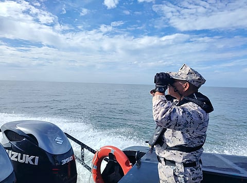 An MMEA officer searches for survivors after a boat carrying migrants from Myanmar capsized near the Malaysia–Thailand border off Langkawi on Nov 9 2025.