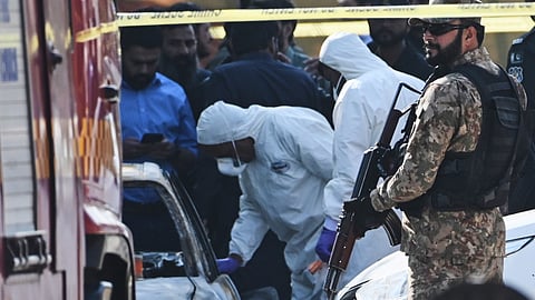 Pakistani investigators examine a damaged car at the site of a suicide bombing outside the gates of a district court, in Islamabad, Pakistan, Tuesday, Nov. 11, 2025.