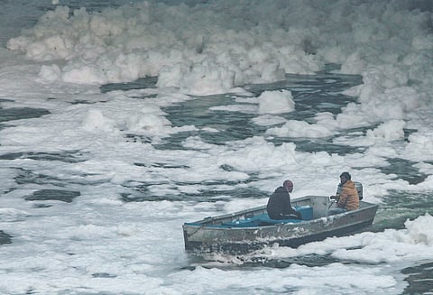 Workers remove toxic foam from the polluted Yamuna river at Kalindi Kunj, in New Delhi, Saturday, Nov. 22, 2025.