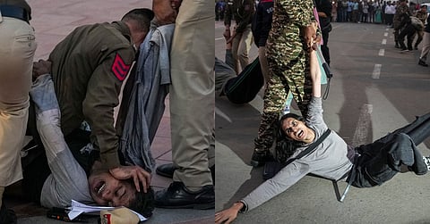 A protester being detained by security personnel during a protest against worsening air quality in the national capital, near the India Gate, in New Delhi, Sunday, November 23, 2025.