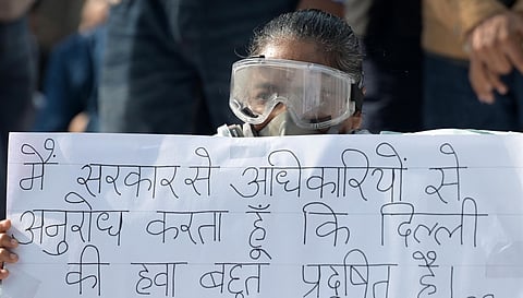 Demonstrator wearing an oxygen mask protests demanding government action to reduce air pollution in New Delhi.