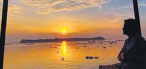 The island appears silhouetted against the rising sun. A view from Kayippuram jetty