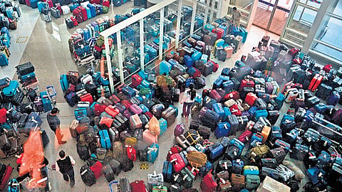 Passengers looking for their bags in the massive buildup of unclaimed luggage at IGI Airport.