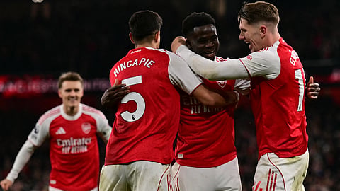 Arsenal's Bukayo Saka (C) celebrates with teammates after his corner kick is diverted into his own net by Wolverhampton Wanderers' goalkeeper Sam Johnston during the EPL football match between Arsenal and Wolverhampton on December 13, 2025.