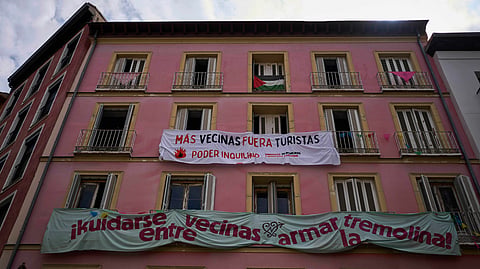 Banners against tourist holiday rentals hang on the facade of a building in downtown Madrid, Spain, Tuesday, June 3, 2025.