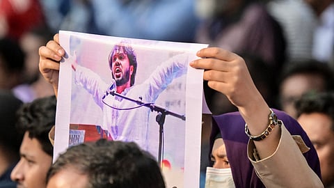 An activist holds a poster of Sharif Osman Hadi, senior leader of the student protest group Inqilab Mancha, who was shot outside a mosque, during a demonstration to condemn the attack in Dhaka on December 15, 2025.