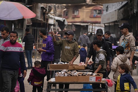 A Palestinian vendor displays sardines for sale on a street of a local market in Gaza City, Friday, Dec. 19, 2025.