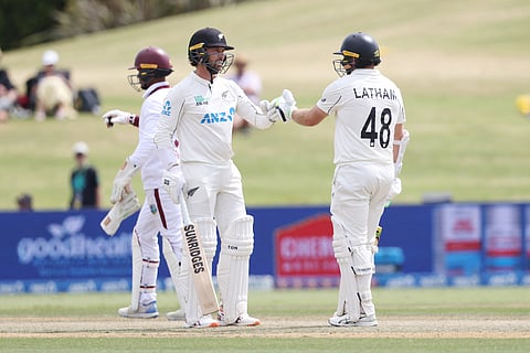 New Zealand’s Devon Conway (L) and Tom Latham touch gloves during day four of the 3rd international Test cricket match between New Zealand and West Indies at Bay Oval in Mount Maunganui on December 21, 2025.