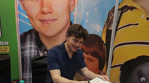 Robert Capron signs a copy of Diary of a Wimpy Kid in Bengaluru