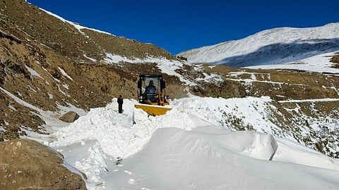 Project Management Unit (PMU) worker clears accumulated snow to restore road connectivity, at Daksum's Sinthan in Anantnag, Wednesday, Dec. 24, 2025.