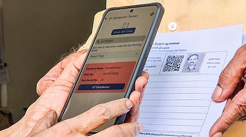 A Special Intensive Revision (SIR) official scans a form during the house-to-house verification process to update voter ID card