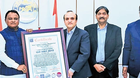 Vigilance DG Yashwant Jethwa presenting the ISO 9001:2015 certification received by State Vigilance Academy for quality training and management standards to CM Mohan Charan Majhi.