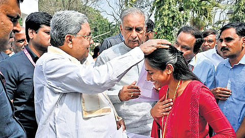 Chief Minister Siddaramaiah hands over an appointment letter to a woman candidate selected for a post in the Karnataka Legislative Council, in Bengaluru on Saturday.