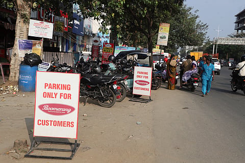 A shopkeeper illegally blocking parking spots on the Tiruchy road in Coimbatore on Monday.