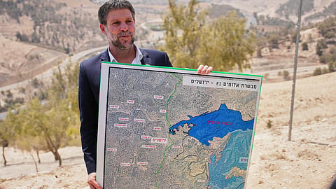 Israeli Finance Minister Bezalel Smotrich holds a map that shows the E1 settlement project during a press conference near the settlement of Maale Adumim, in the Israeli-occupied West Bank, Aug. 14, 2025.