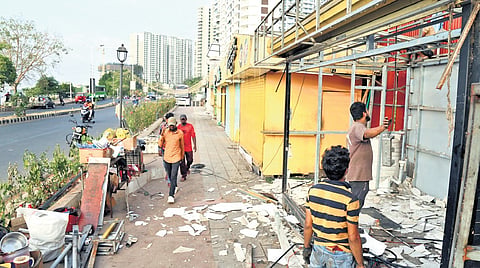 Workers removing the existing food kiosks on Queens Walkway as part of the renovation work