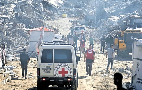 Red Cross personnel walk amid the ruins in Jabalia, Gaza Strip
