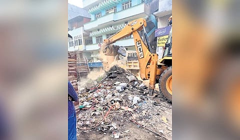 Workers remove garbage and construction debris in Central City Corporation limits on Sunday