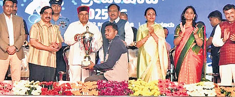 Governor Thaawarchand Gehlot presents the champion trophy to an athlete at the closing ceremony of Karnataka Games at Mahatma Gandhi stadium in Tumakuru on Thursday evening. Home Minister Dr G Parameshwara looks on