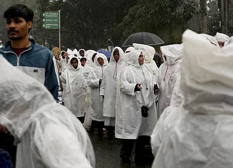 Visitors arrive to attend full-dress rehearsal for the Republic Day Parade amid rainfall, in New Delhi, Friday, Jan. 23, 2026.