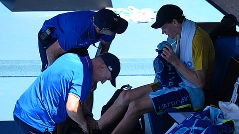 Jannik Sinner of Italy receives treatment from trainers during his third round match against Eliot Spizzirri of the U.S.at the Australian Open tennis championship in Melbourne, Australia, Saturday, Jan. 24, 2026.