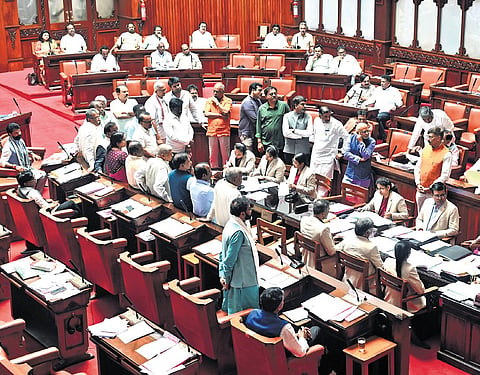 Opposition members protest in the well of the Council during the session in Vidhana Soudha on Wednesday