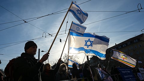 Participants gather hold up Israeli flags during a demonstration in Leipzig, Germany, Saturday, Jan. 17, 2026.