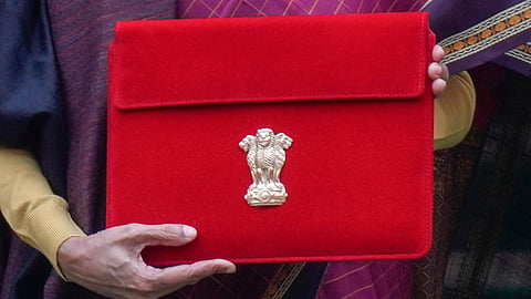 Finance Minister Nirmala Sitharaman shows the digital tablet, enclosed in a traditional red 'bahi-khata' style pouch, at the Parliament premises before presenting of the Union Budget 2026-27, in New Delhi, Sunday, Feb. 1, 2026.