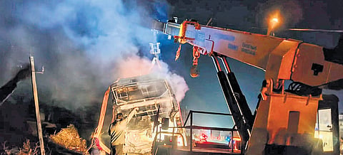 Smoke billows from a private bus after it catches fire, near Nelamangala, on the outskirts of Bengaluru on Friday.