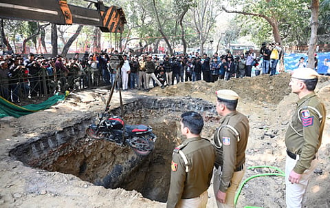 The bike of a motorcyclist who plunged into an uncovered pit dug for construction work by Delhi Jal Board, being lifted out.