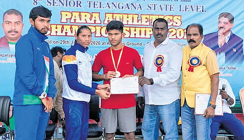 Bronze medal winner at the 2024 Paralympics, Deepthi Jeevanji, awards a medal to para-athlete Ganapathi Rathlavath at a state-level athletics competition.