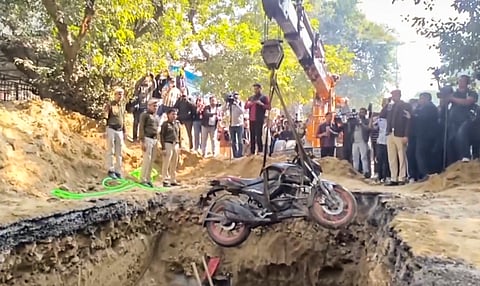 The bike of a motorcyclist who plunged into an uncovered pit dug for construction work by Delhi Jal Board, being lifted out, at Janakpuri, in New Delhi, Friday, Feb. 6, 2026.
