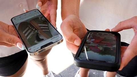 Young people use their phones to view social media in Sydney, Nov. 8, 2024.