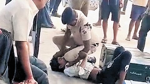 Screengrab from a video shows an RPF constable restraining, assaulting youth at Tiruvottiyur railway station